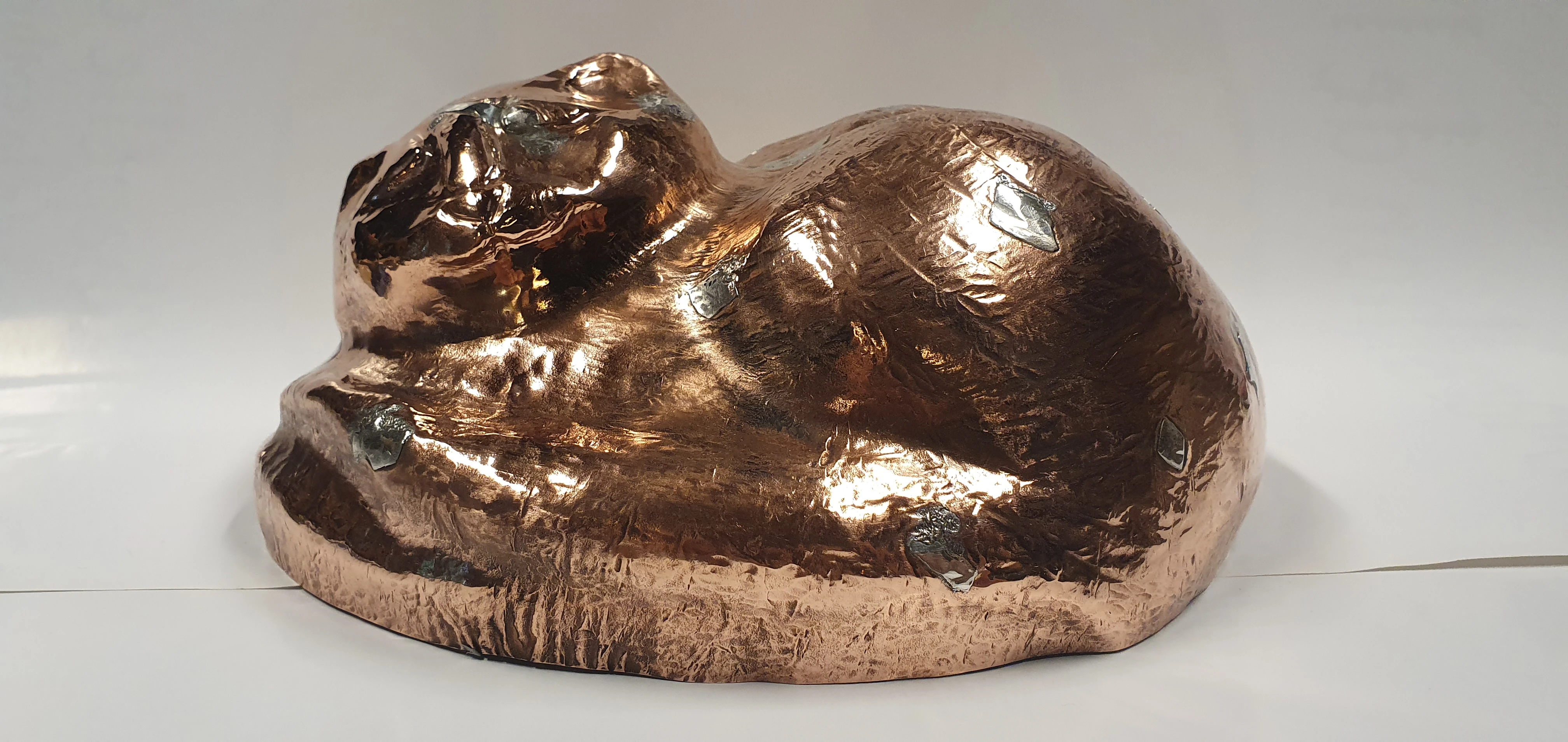 Chat couché en cuivre